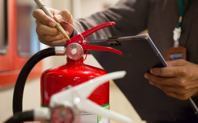 Trabajador usando un extintor en práctica contra incendios
